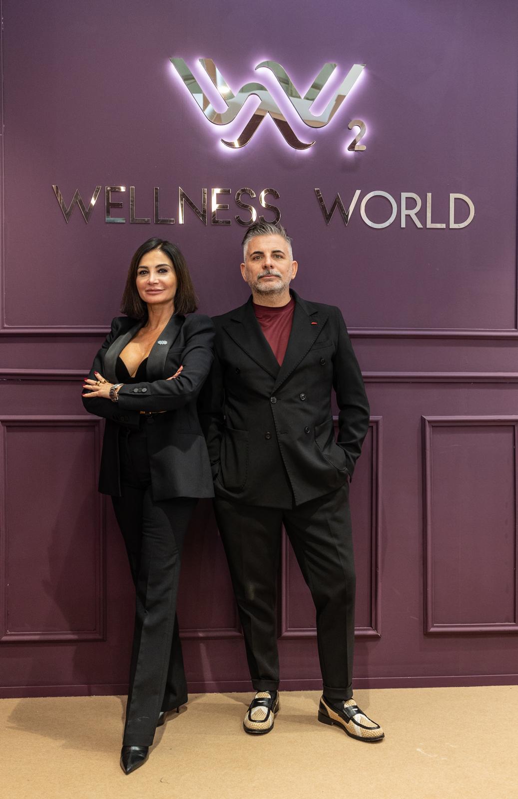 I titolari di Wellness World davanti alla parete con il logo WW²